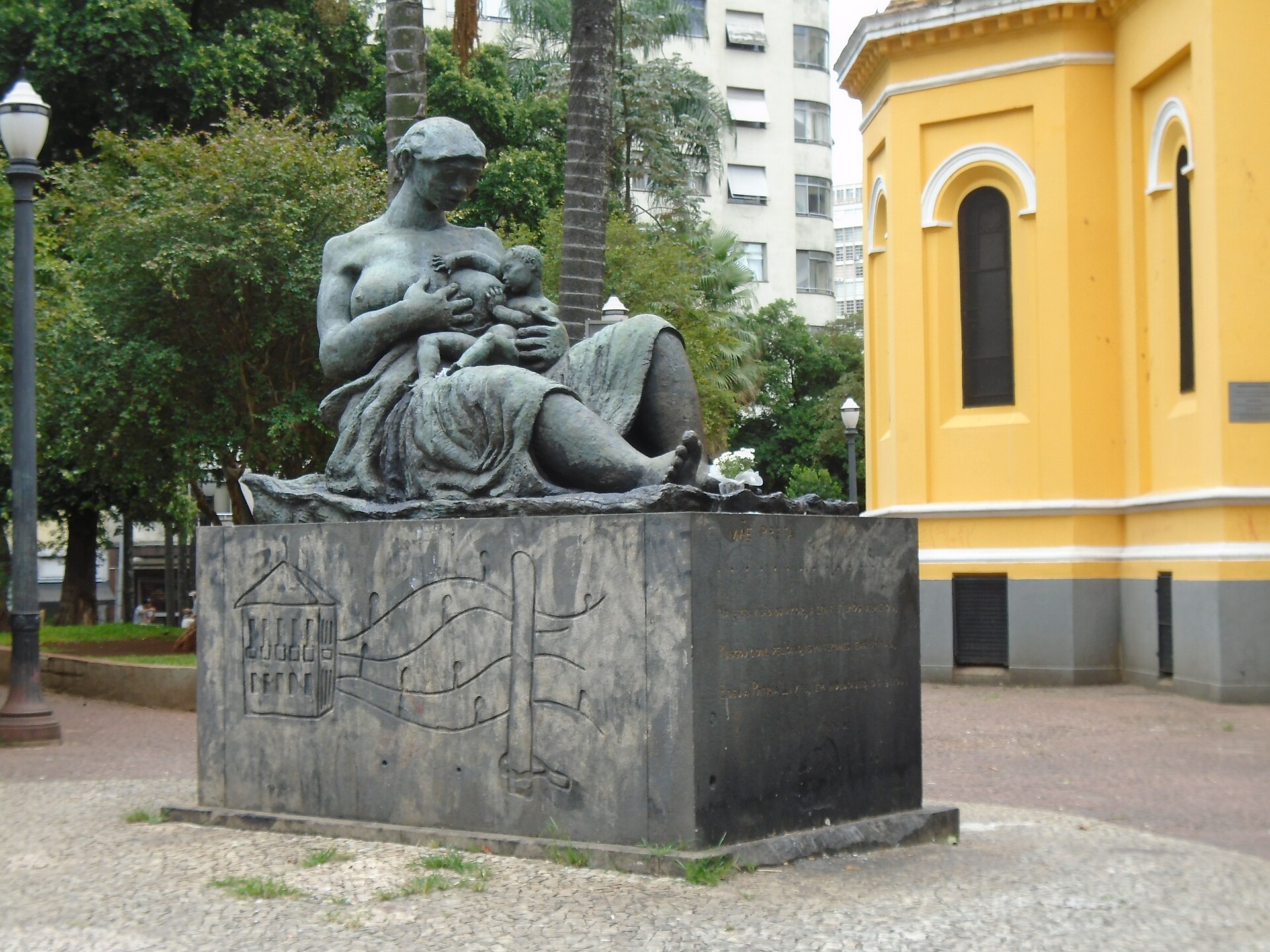 Imagem de referência de Mãe Preta, descrito nos dados abertos como escultura de bronze representando uma mulher negra amamentando criança branca