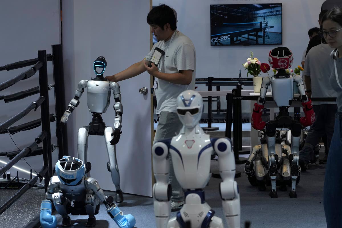 A worker gets a robot ready for demonstration at a booth for leading Chinese commercial humanoid robotics firm Unitree Robotics during the World AI Conference in Shanghai, China, on July 18, 2026.