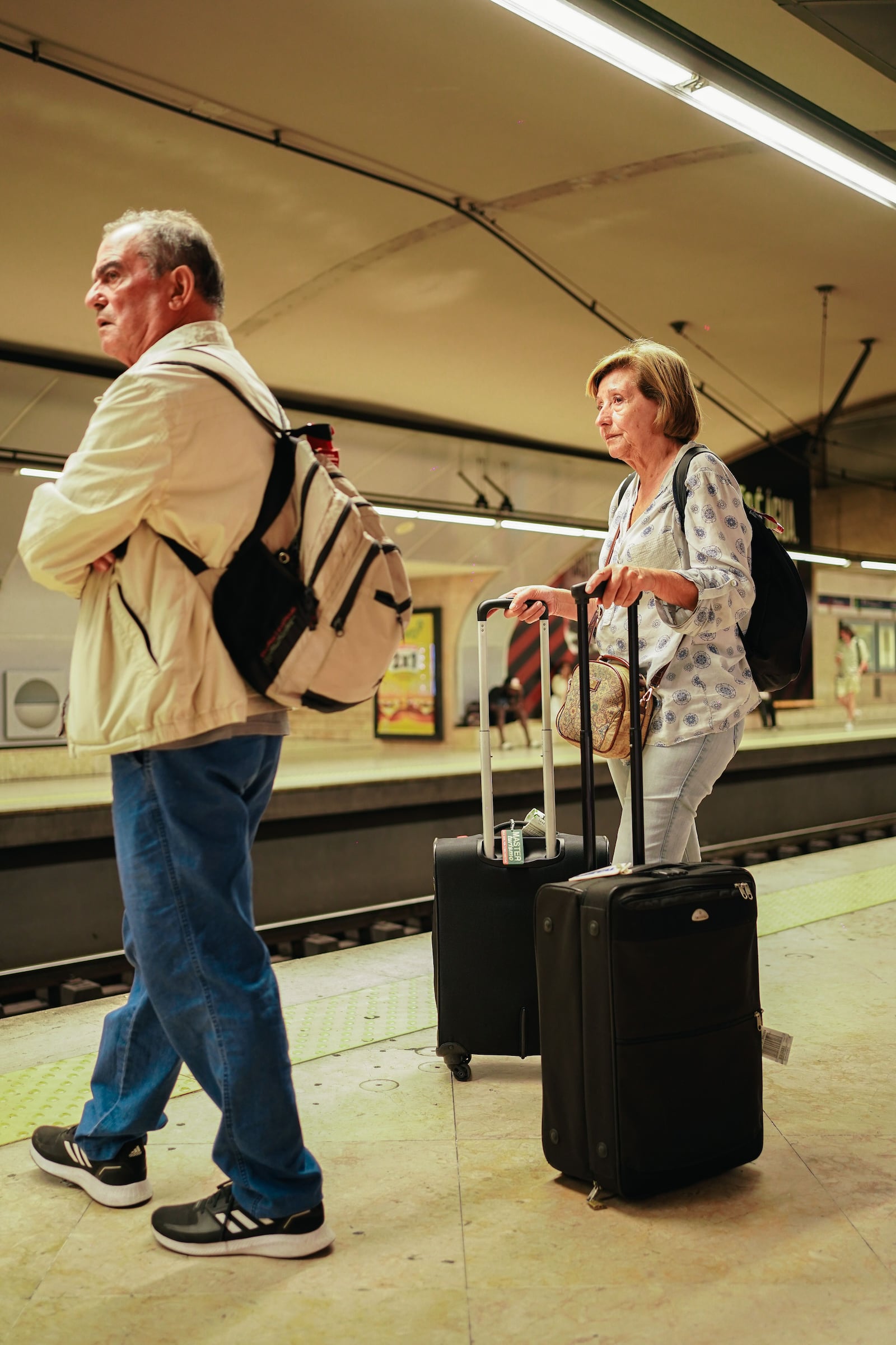 Casal idoso com bagagens em uma plataforma de metrô, prontos para uma aventura de viagem. Pexels / Shojol Islam